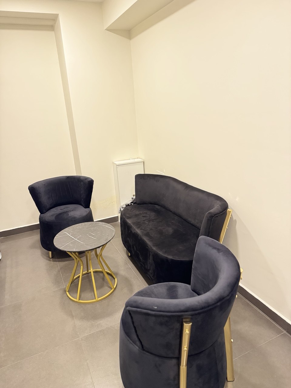 GentlemanLazer oturma alanı — siyah kadife koltuklar ve altın detaylar