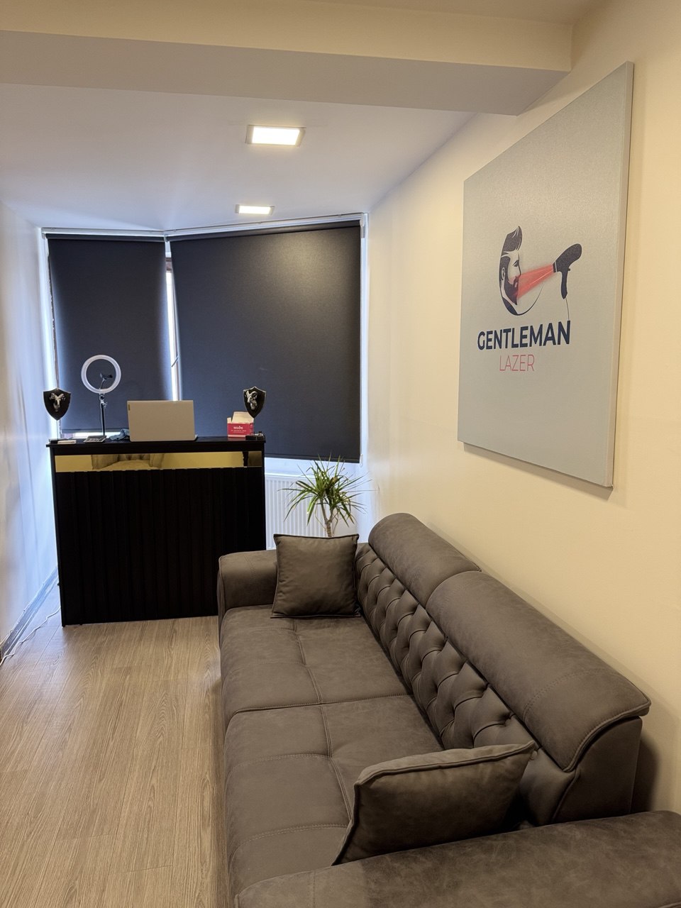 GentlemanLazer karşılama alanı — logo panosu ve gri koltuk